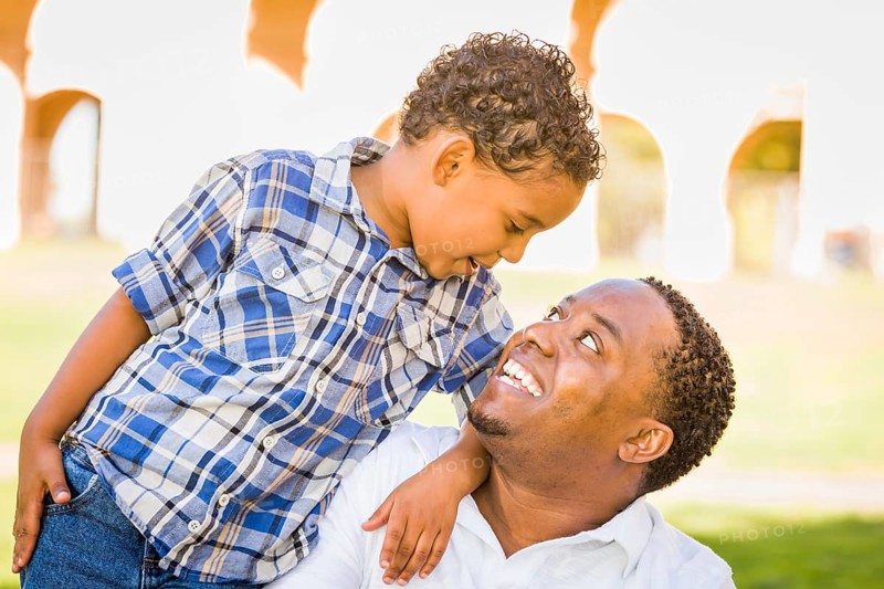 Happy african american father and mixed-race son playing at the park