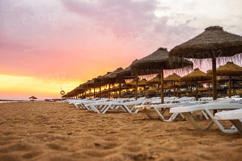 Beautiful colorful sunset over sun beds and umbrellas in Vilamoura