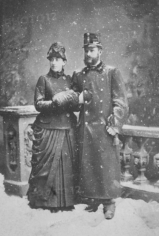 Married couple standing in the snowfall