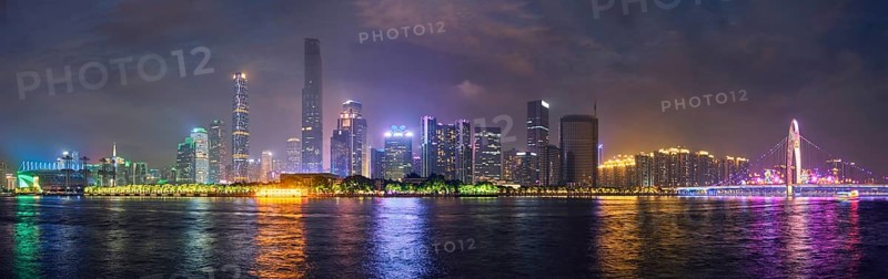 Guangzhou cityscape skyline over the Pearl River with Liede Bridge illuminated in the evening. Guangzhou