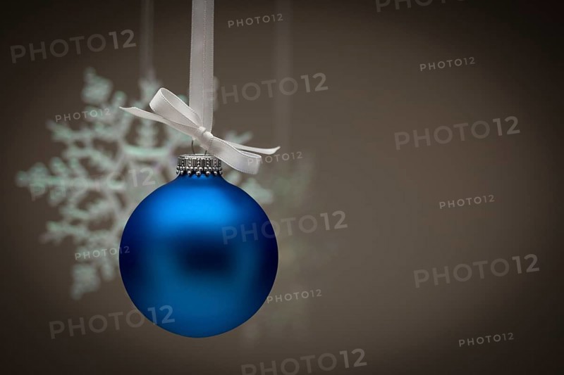 Snowflake and blue christmas ornament against dark background