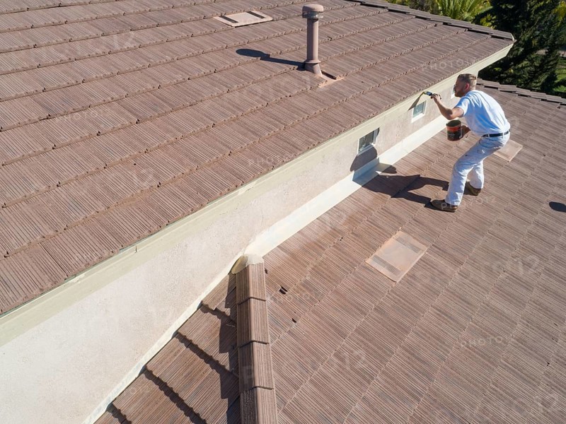Professional painter using A brush to paint house facade