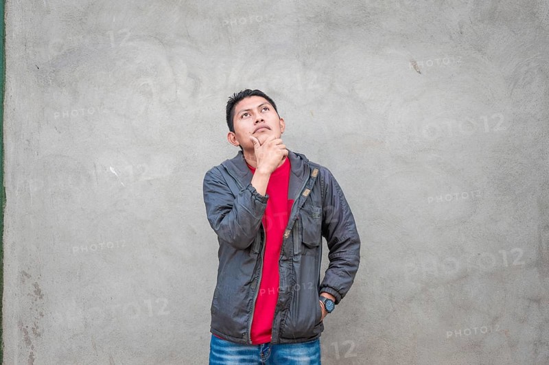 Young man wondering with his hand on his chin on an isolated background