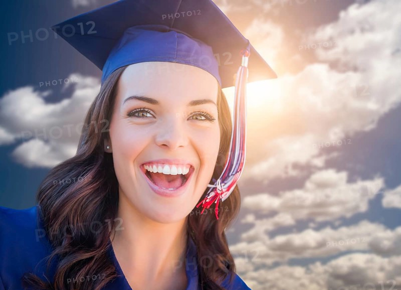 Happy graduating mixed-race woman in cap and gown