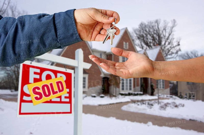Handing over the house keys in front of a beautiful new home