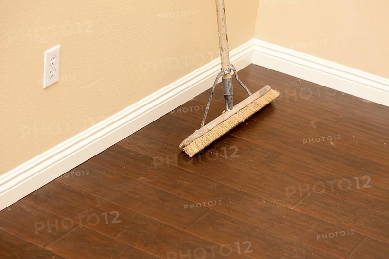 Push broom on a newly installed laminate floor and new baseboards