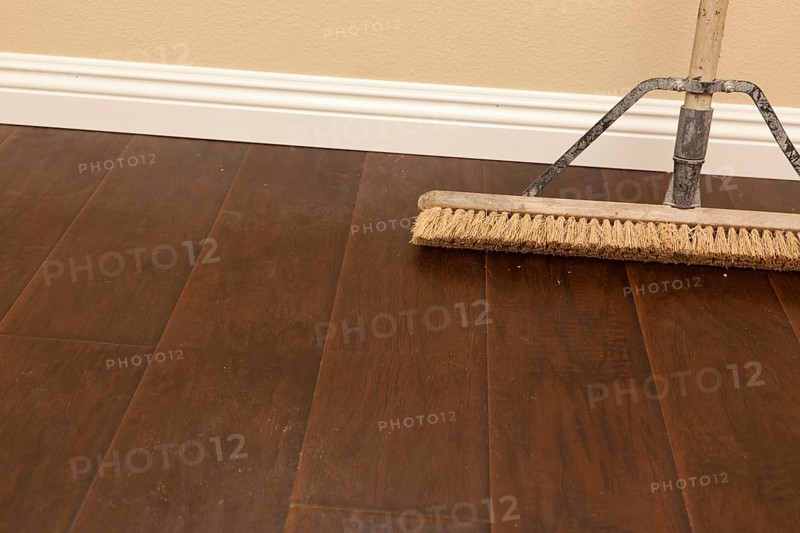 Push broom on a newly installed laminate floor and new baseboards