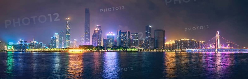 Guangzhou cityscape skyline over the Pearl River with Liede Bridge illuminated in the evening. Guangzhou