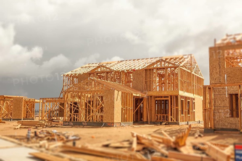 Wood home framing abstract at construction site with stormy clouds behind