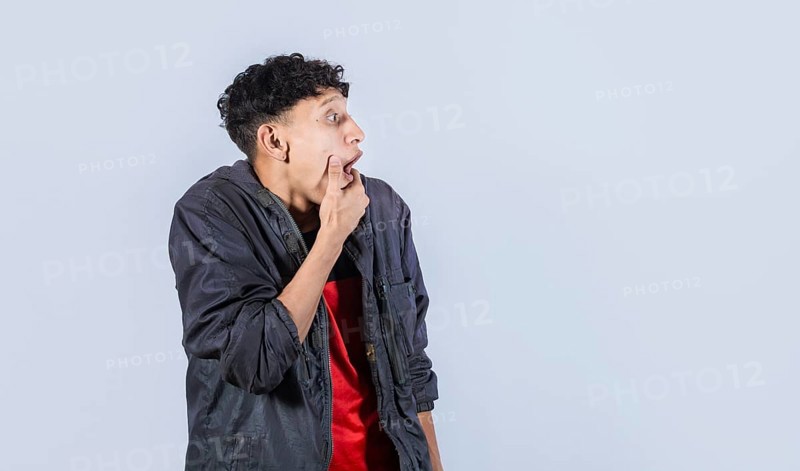 Amazed young man with hand near open mouth
