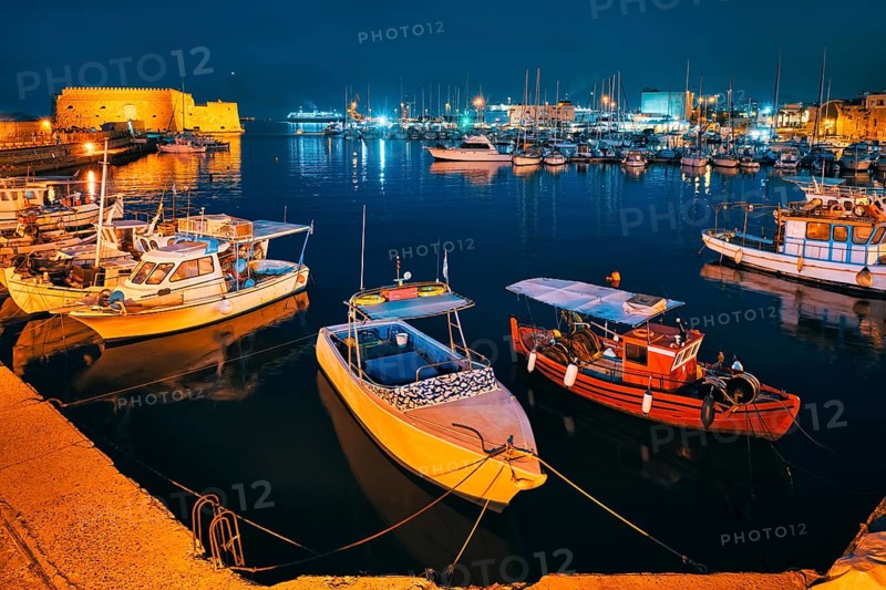 Venetian Fort castle in Heraklion and moored Greek fishing boats in port