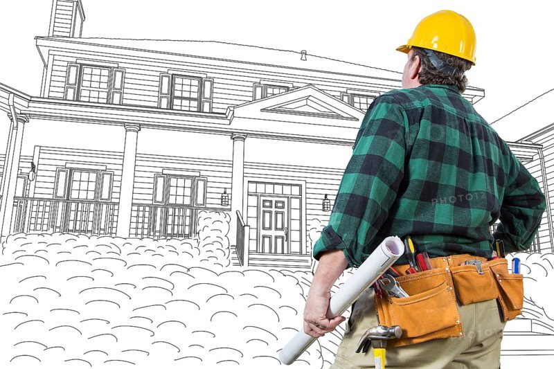 Male contractor with hard hat and tool belt looking at custom house drawing on white