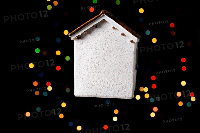 Little model house on a bokeh ligh ton a dark background