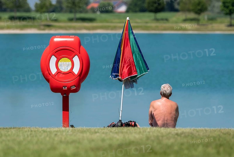 A man sits on the bank of the Kronthaler Weihers in Erding