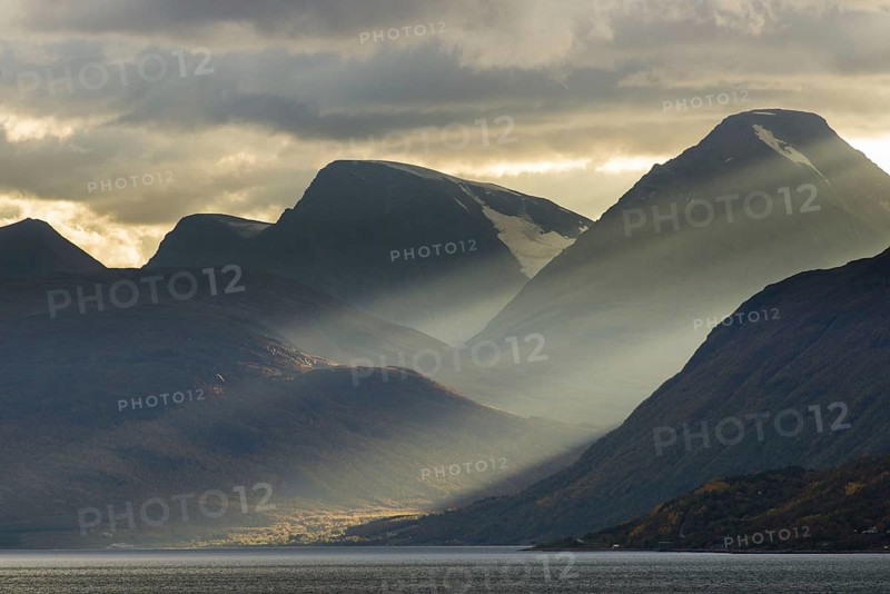 Clouds and sunbeams above fjord
