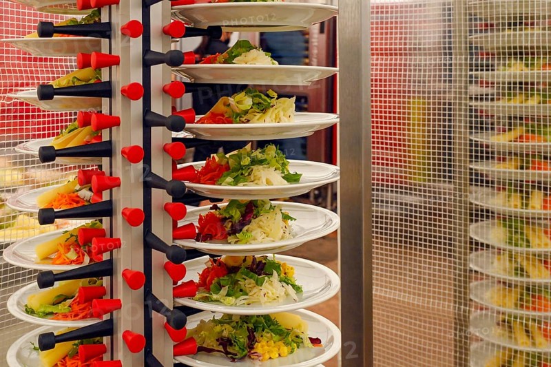 Stacked plates of mixed salad with sliced cheese and sprouts