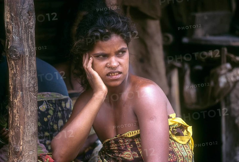 Betta Kurumba woman sitting in front of her hut