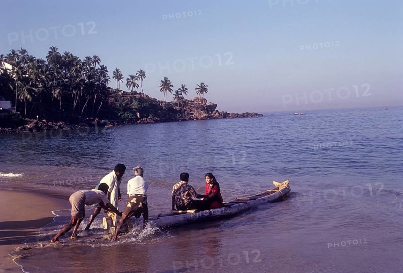 A couple enjoying a catamaran or kattumaram ride at Kovalam beach near Thiruvananthapuram