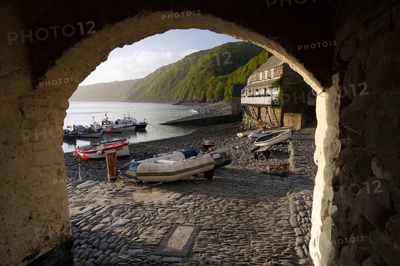 View through archway of fishing boats and wharf houses at dawn