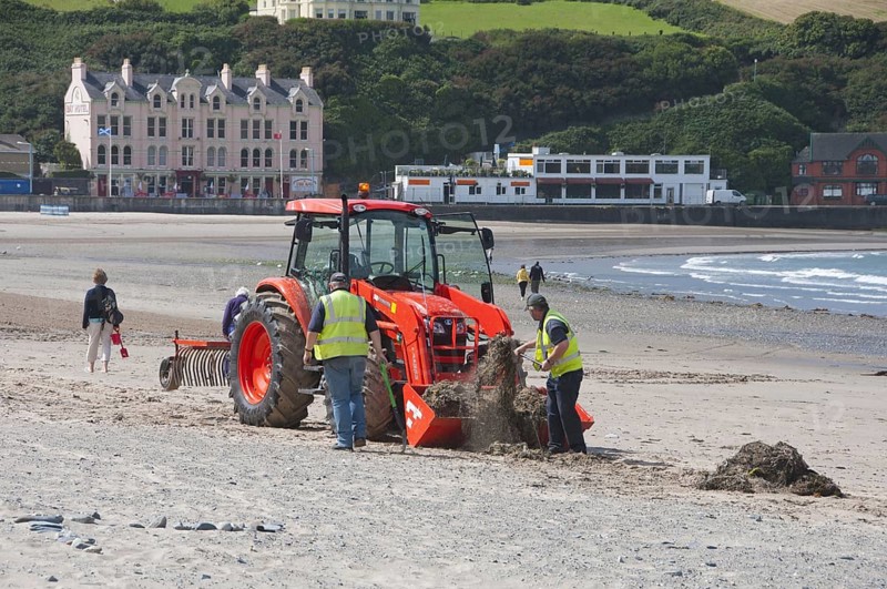 Workers with tractor on beach