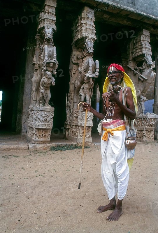 Vaishnavite devotee standing in front of Shesharayar Mandapam sculptures in Srirangam temple