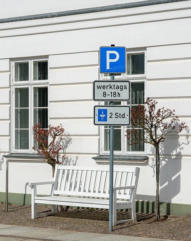 Traffic sign for temporary parking in front of white house wall