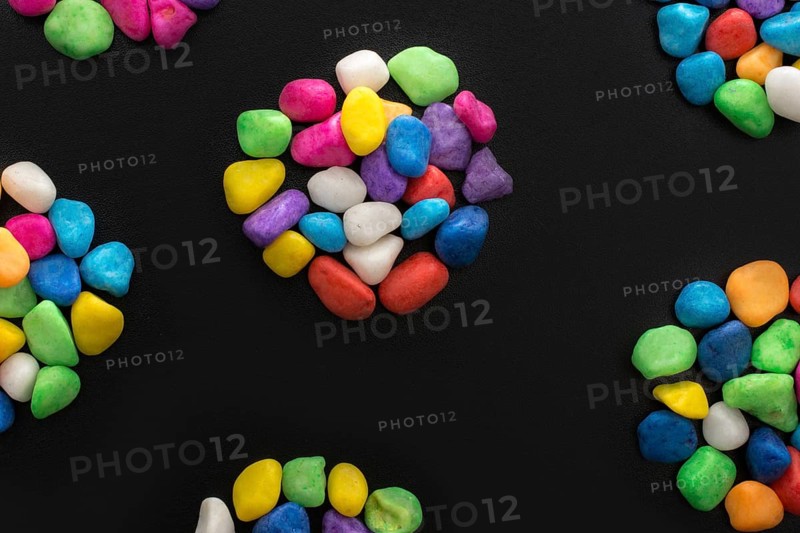 Pile of little colorful pebbles on black background