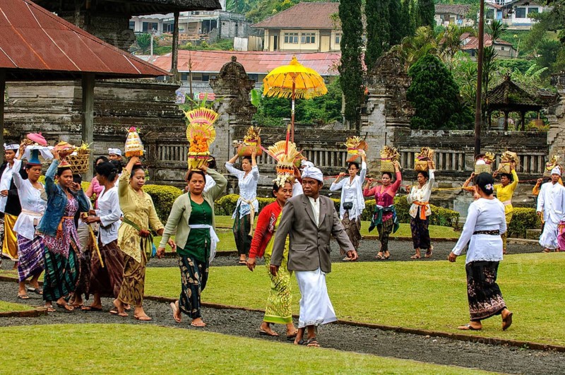 Procession of Hindu worshippers walking with offerings to temple