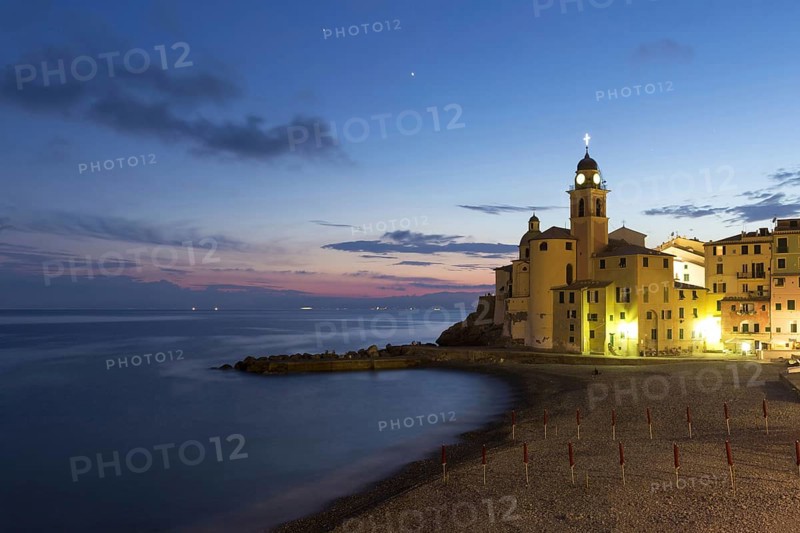 View of coastal village with church and beach at night