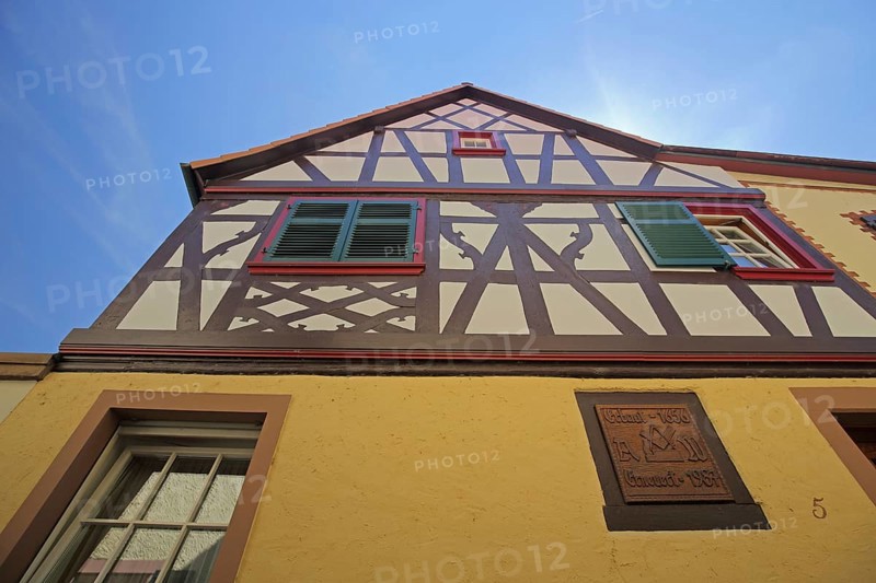 View upwards to the gable of a half-timbered house with shutters in Oestrich