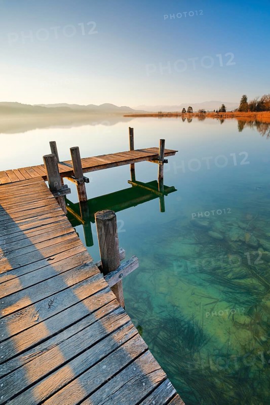 Holzsteg am Pfaeffikersee bei Sonnenaufgang mit Blick zum Bachtel und Glaernisch im Hintergrund