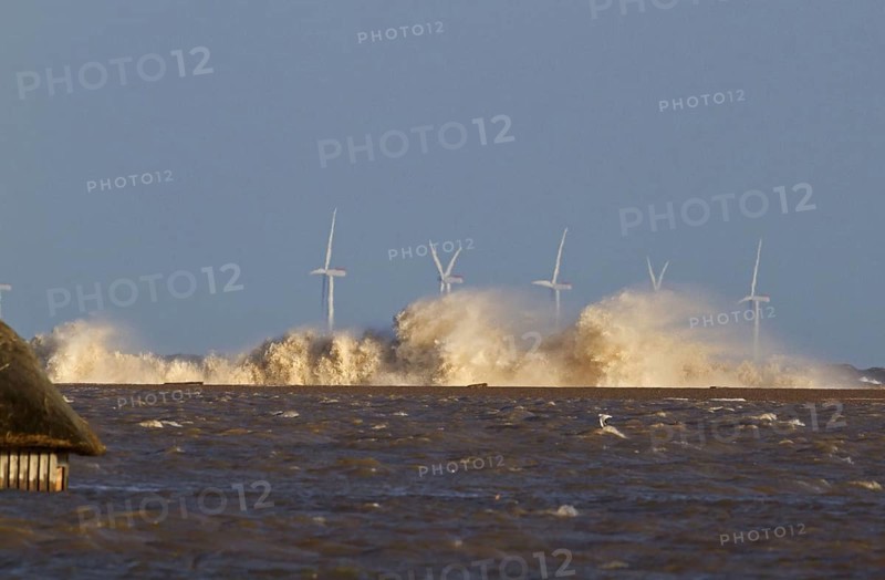 Waves crashing against remains of shingle sea defences