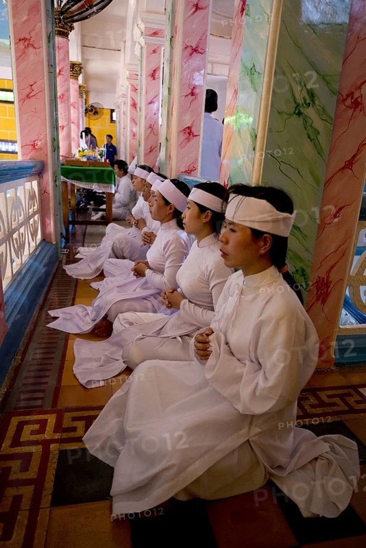 Caodaist disciples sitting on balcony during ceremony
