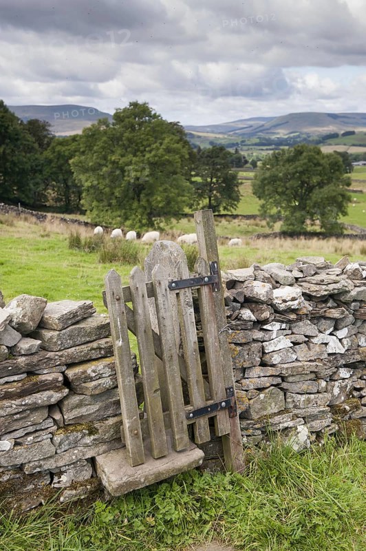 Stiles and gate in dry stone wall on public footpath