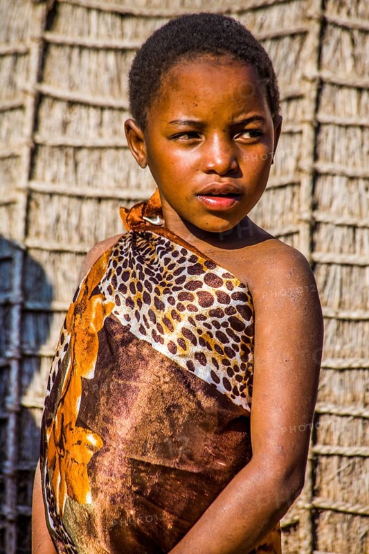 Children watch with interest at traditional customs in real African village