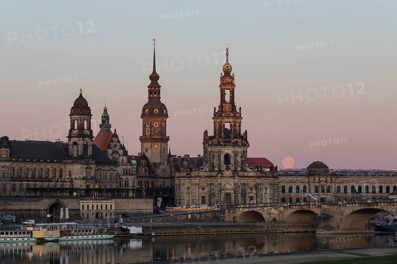 Sunrise and full moon behind the silhouette of the old town with the towers of the Staendehaus