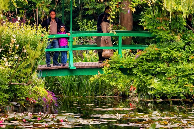 Japanese bridge over lily pond with visitors