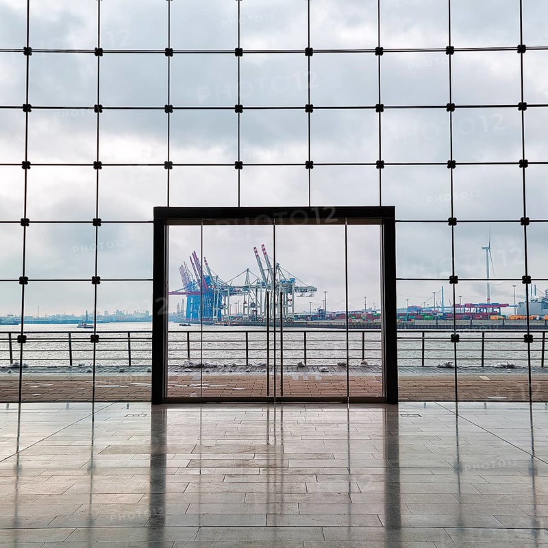 View through modern glass facade with large door onto the harbour