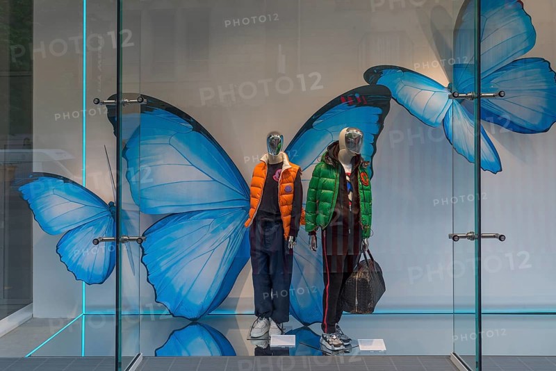 Shop window with fashionable mannequins and large paper butterflies