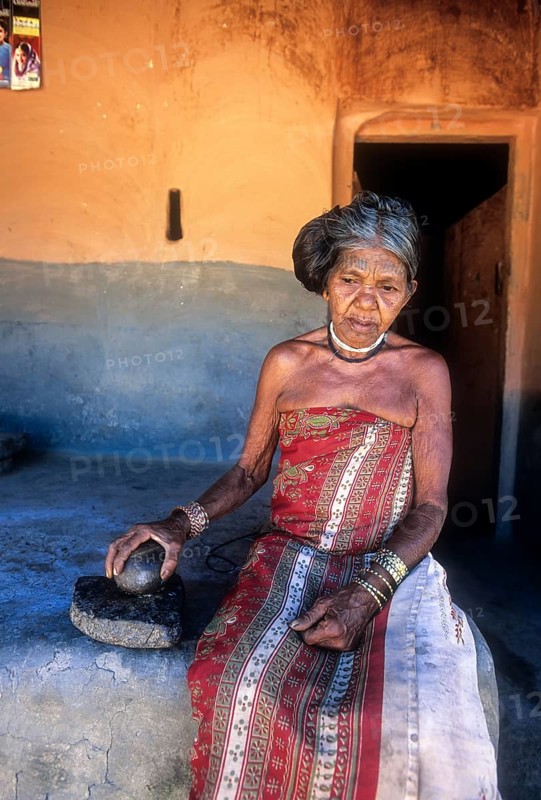 Mudunga tribal old lady sitting in front of the hut
