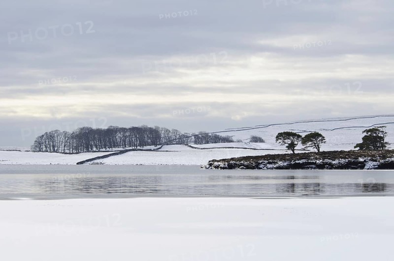 View of a partially frozen and snow-covered glacial lake