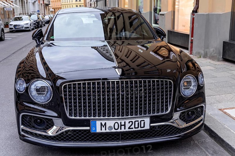 Parked luxury sedan Bentley Flying Spur First Edition in front of fashion shop Boutique Dior