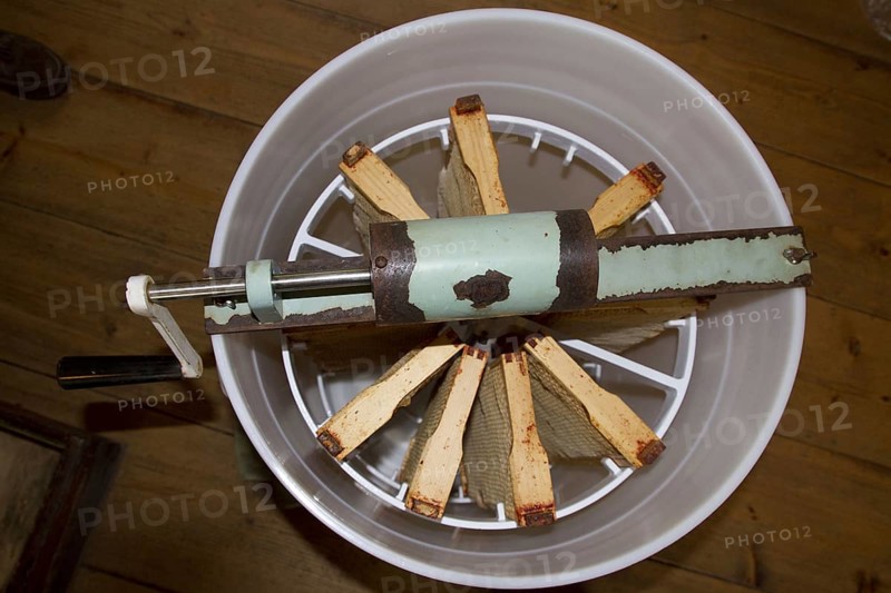 The honeycomb frames are placed in a centrifugal drum and then spun at high speed to separate the honey from the combs
