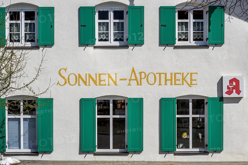 Fassade mit gruenen Fensterlaeden