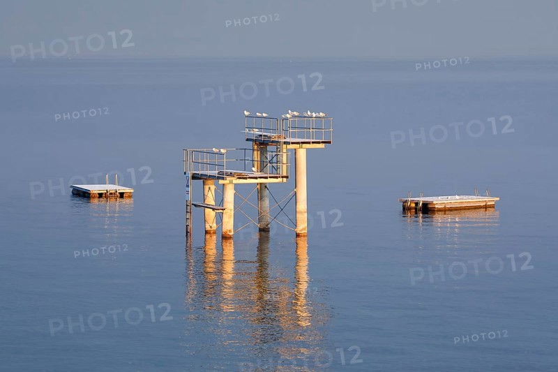 Morgenstimmung ueber dem Bodensee mit Blick zum Sprungturm und den Flossen der Freibadanlage Horn inmitten des Sees