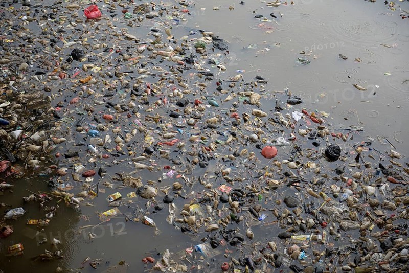 Rubbish floating on river in city