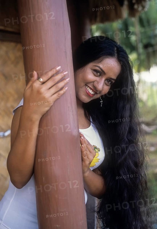A woman standing in a hut with smiling