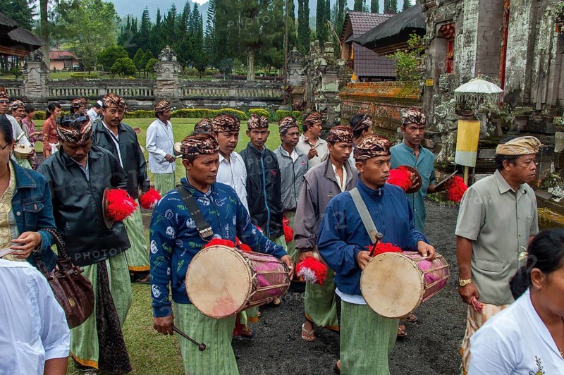 Balinese musicians carrying traditional instruments in procession