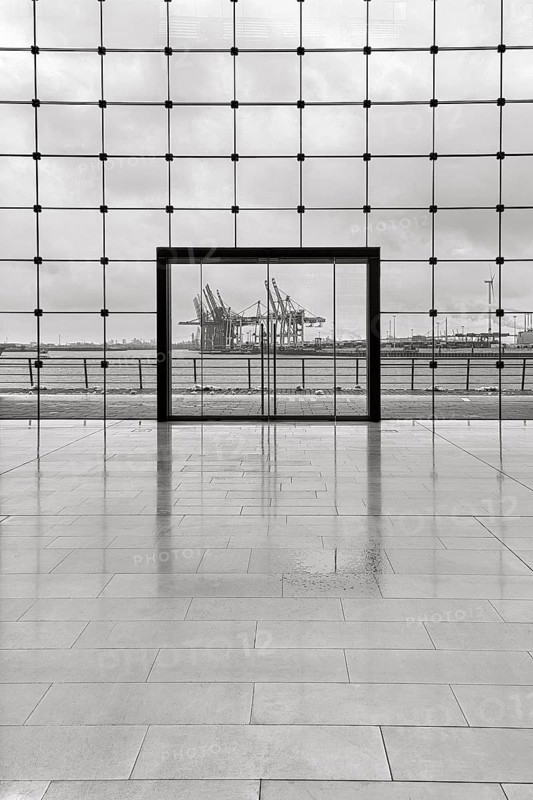 View through modern glass facade with large door onto the harbour