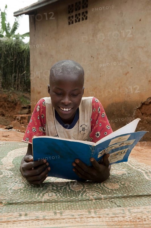 Children reading from a textbook at home